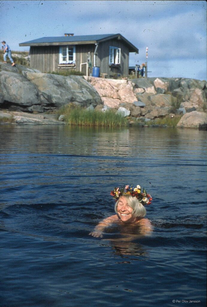 Tove Jansson swimming with her birthday flower crown on Klovharun. Photo: Per Olov Jansson